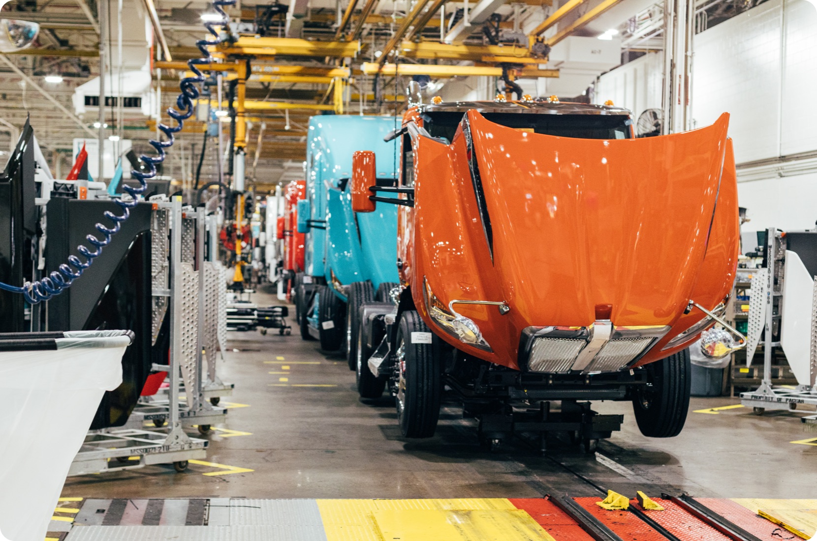 Heavy trucks being assembled at an automotive plant.