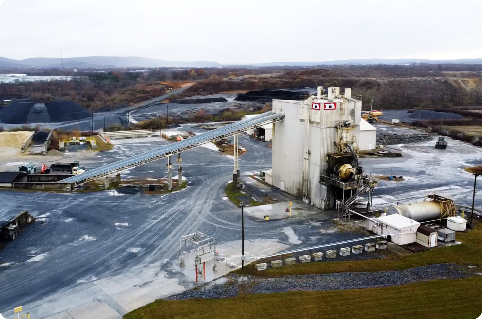 Mining plant showing large building and auger/conveyor.