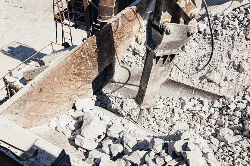 Concrete or rock being broken up by industrial machinery.