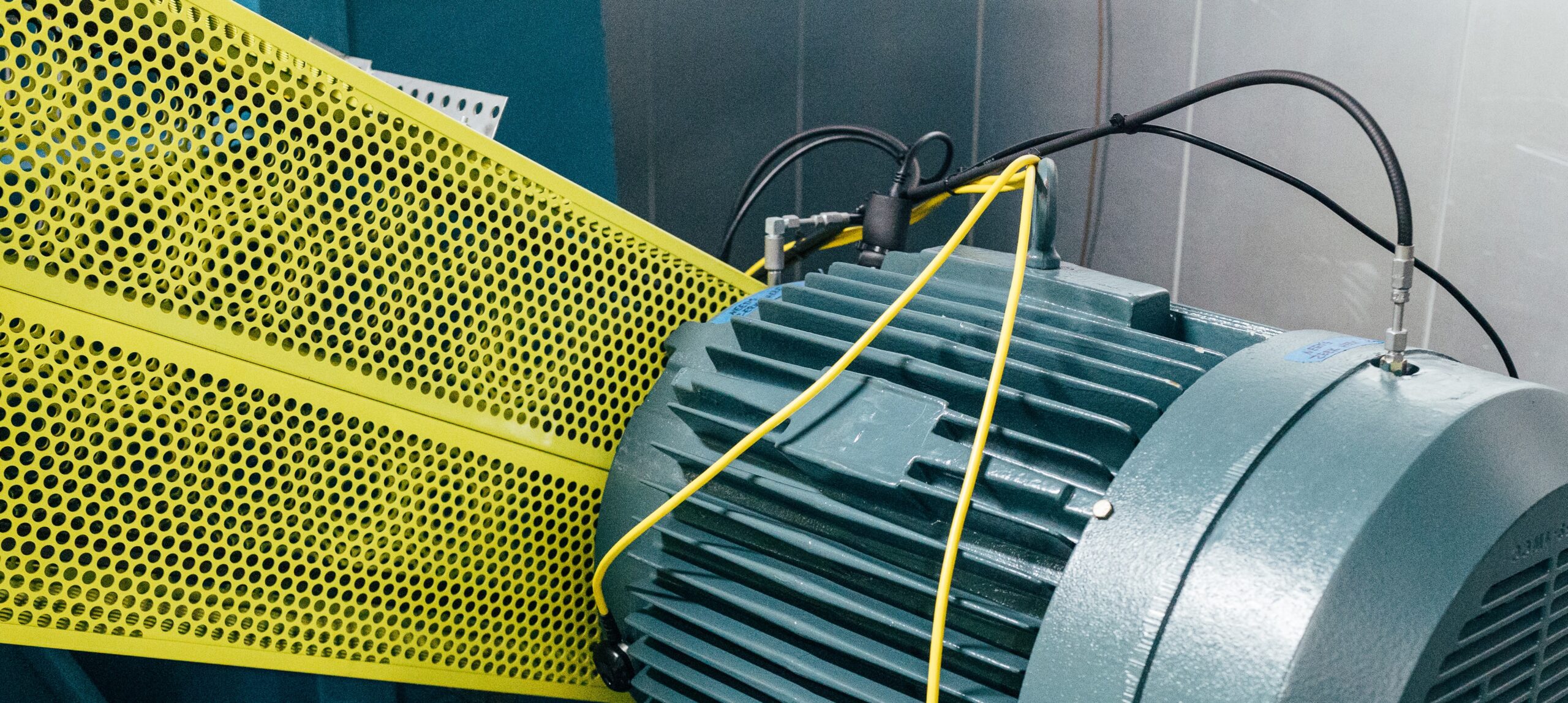 Motor shown besides yellow metal rail that needs condition monitoring.
