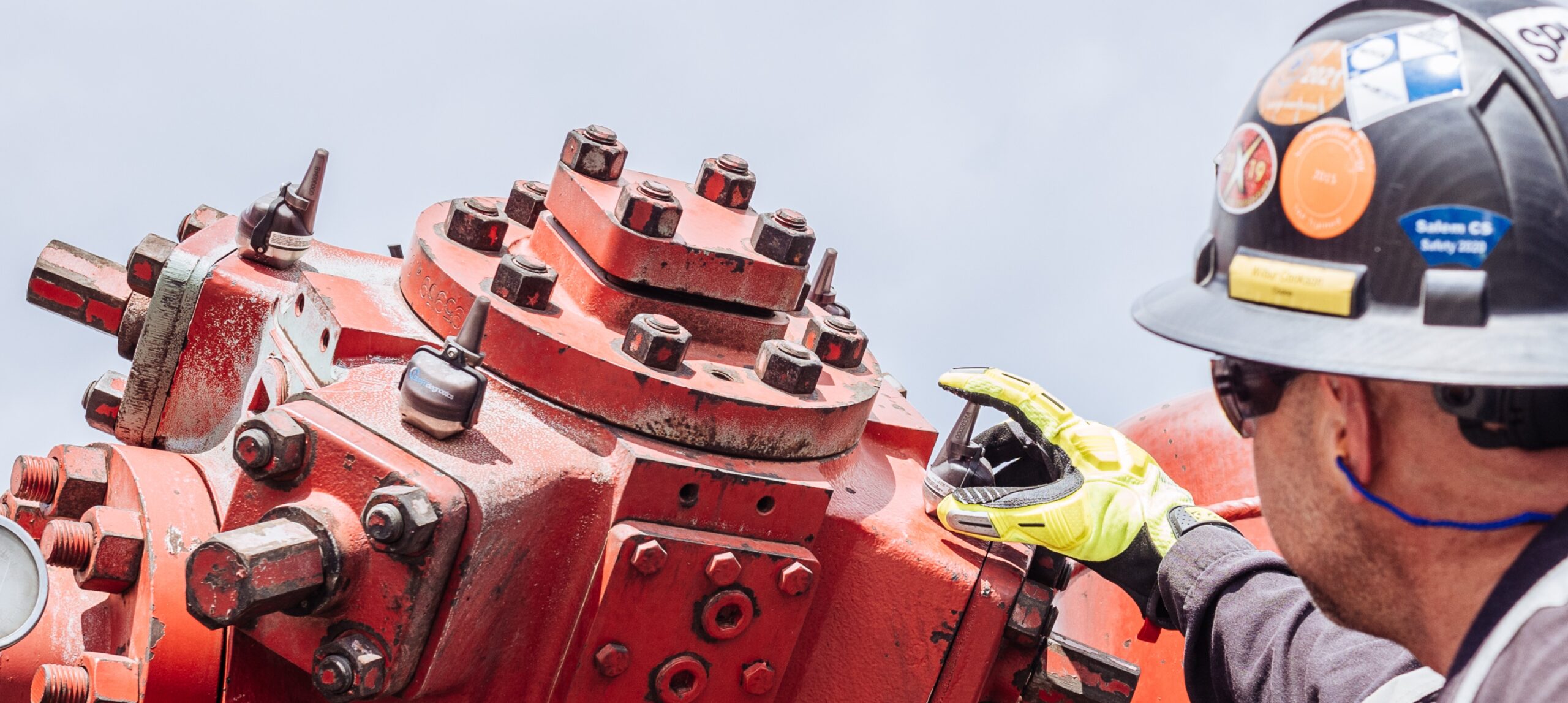 A KCF Technologies staff member places a vibration monitor on industrial machinery to empower machine health monitoring.