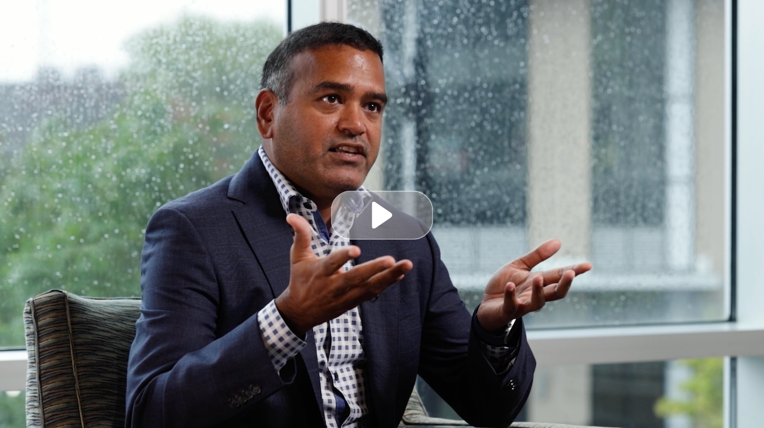 Person gesturing while speaking indoors.